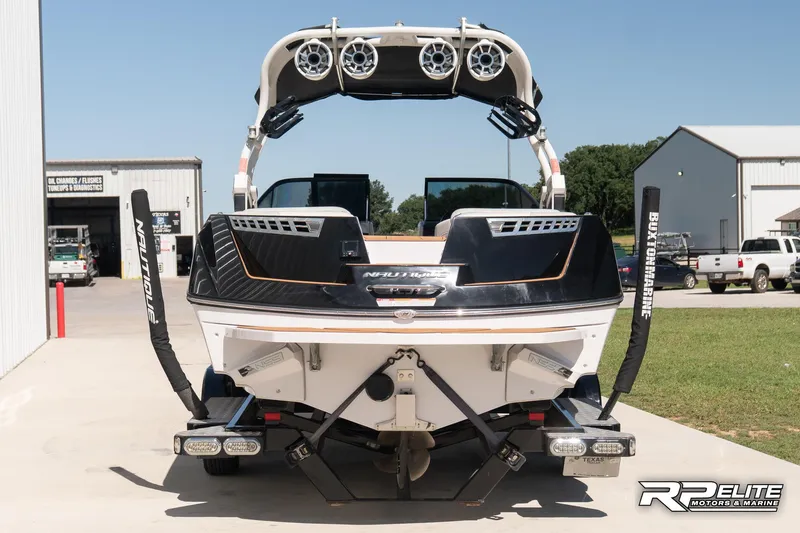 Slide: The Image of 2014 Nautique Super Air Nautique 230 boat, rear view with speakers and wakeboard racks. - 7
