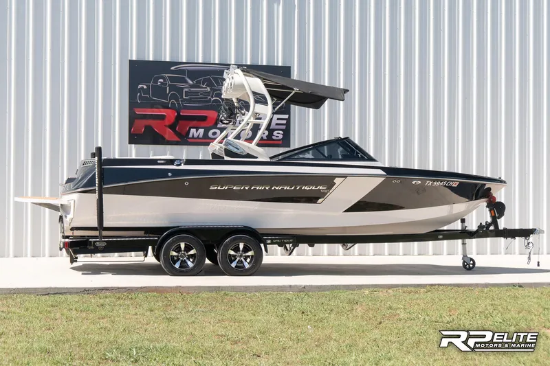 Slide: The Image of 2014 Nautique Super Air Nautique 230 boat on trailer, displayed outdoors. - 9