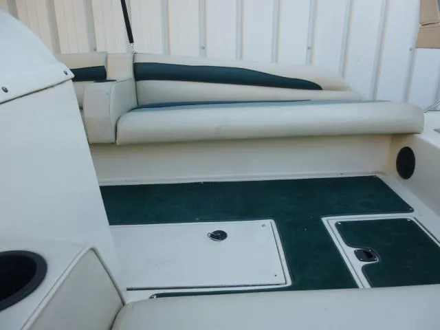 Slide: The Image of Interior of 2000 SeaArk Sunstar 21 boat with green carpet and white seating. - 12