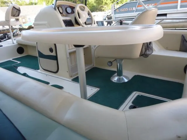 Slide: The Image of Interior of 2000 SeaArk Sunstar 21 boat with steering wheel and seating area. - 17