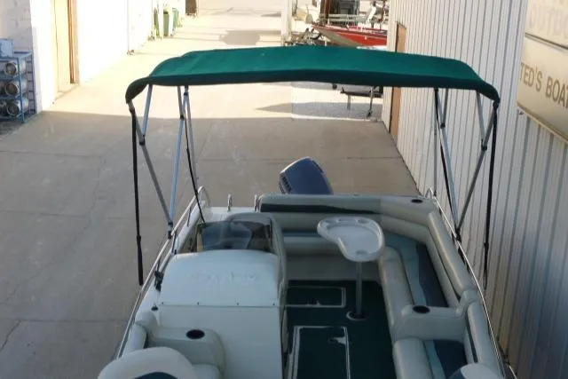 Slide: The Image of SeaArk Sunstar 21 boat, 2000 model, with green canopy and spacious seating. - 19