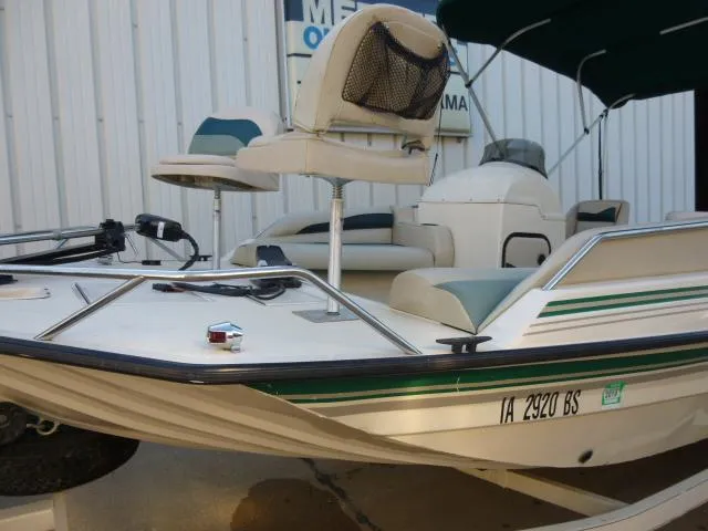 Slide: The Image of 2000 SeaArk Sunstar 21 boat with seating, green accents, and registration number IA 2920 BS. - 2