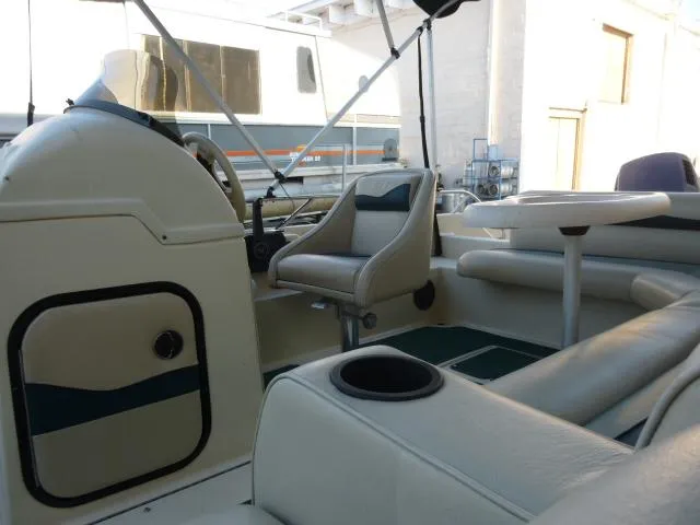 Slide: The Image of Interior of a 2000 SeaArk Sunstar 21 boat with seating and steering console. - 22