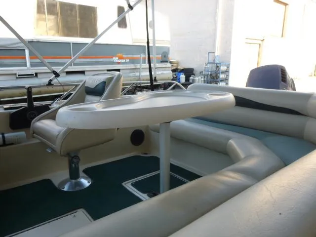 Slide: The Image of 2000 SeaArk Sunstar 21 boat interior with seating and table setup. - 23