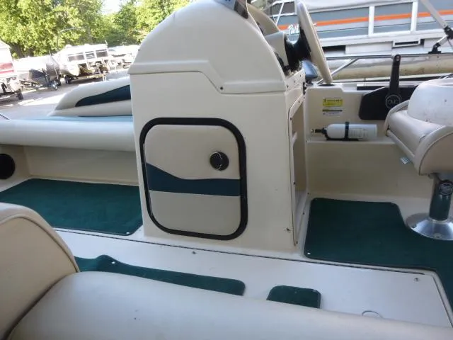 Slide: The Image of Interior of a 2000 SeaArk Sunstar 21 boat with green carpet and seating. - 25