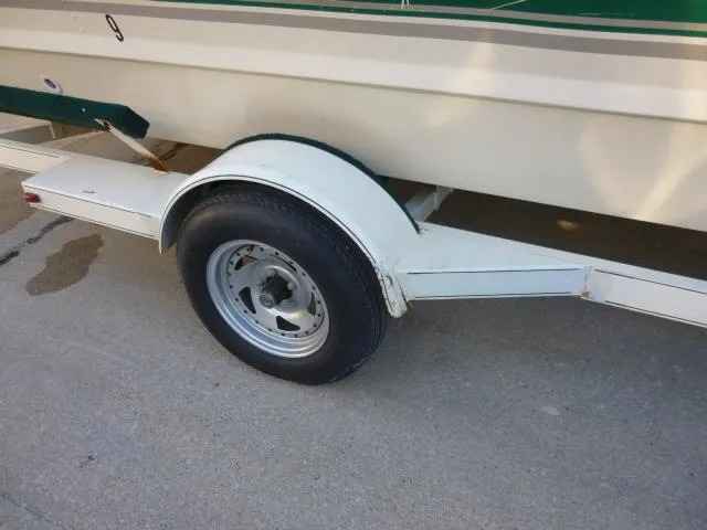 Slide: The Image of Trailer wheel of a 2000 SeaArk Sunstar 21 boat on pavement. - 27