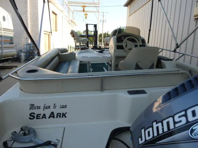 Slide: The Image of 2000 SeaArk Sunstar 21 boat with Johnson motor, docked near a building. - 29