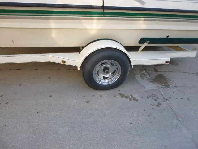 Slide: The Image of Trailer wheel of a 2000 SeaArk Sunstar 21 boat on pavement. - 30