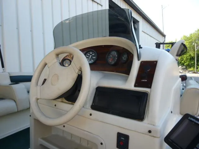 Slide: The Image of Steering console of a 2000 SeaArk Sunstar 21 boat with gauges and controls. - 31