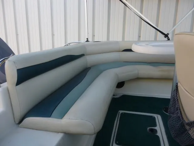 Slide: The Image of Interior seating of a 2000 SeaArk Sunstar 21 boat with white and green upholstery. - 32