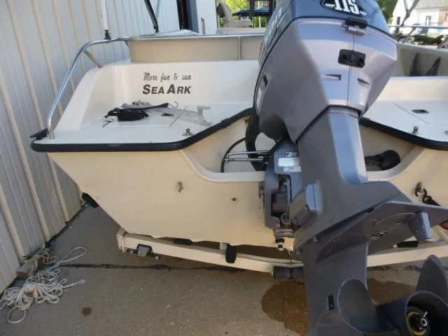 Slide: The Image of 2000 SeaArk Sunstar 21 boat with outboard motor, docked on concrete surface. - 4
