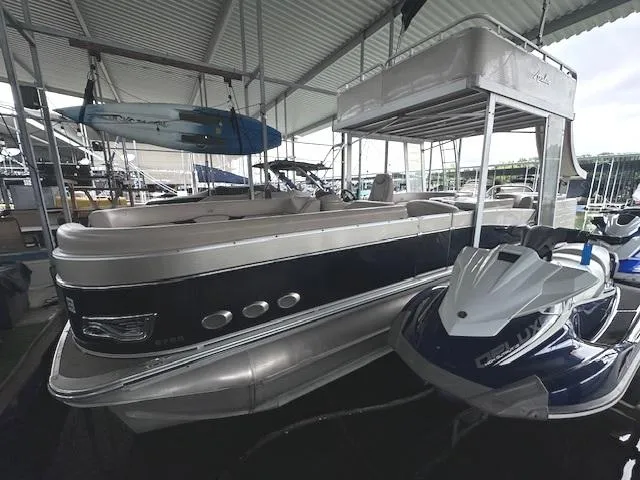 Slide: The Image of 2016 Tahoe Pontoon Vista Funship Entertainer 27' docked with jet ski nearby. - 1