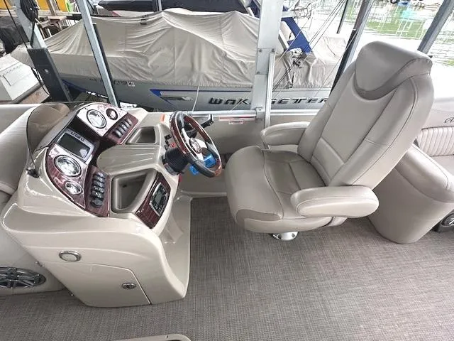 Slide: The Image of 2016 Tahoe Pontoon Vista Funship Entertainer interior with captain's chair and control panel. - 19