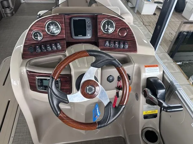 Slide: The Image of 2016 Tahoe Pontoon Vista Funship Entertainer dashboard with wood accents and modern controls. - 21