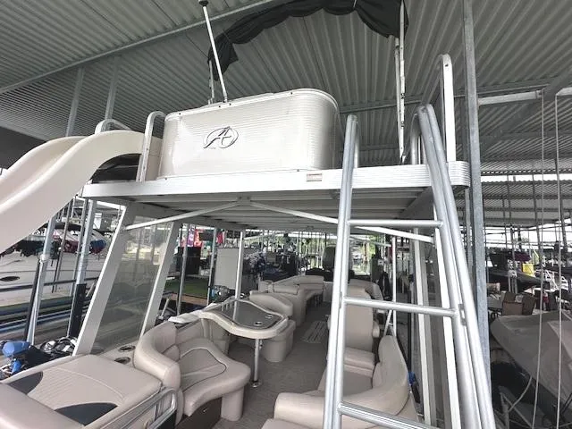 Slide: The Image of 2016 Tahoe Pontoon Vista Funship Entertainer with slide and seating, docked under cover. - 24