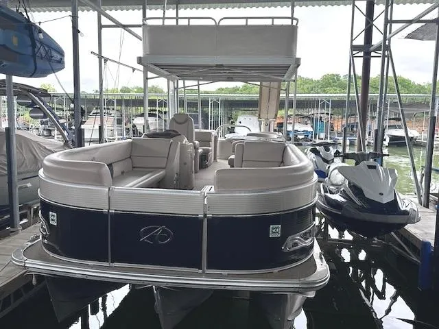 Slide: The Image of 2016 Tahoe Pontoon Vista Funship Entertainer - 27' docked beside a jet ski. - 9