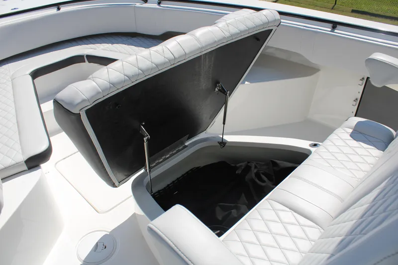 Slide: The Image of 2023 Fountain 34 CC boat interior with open storage compartment and cushioned seating. - 16