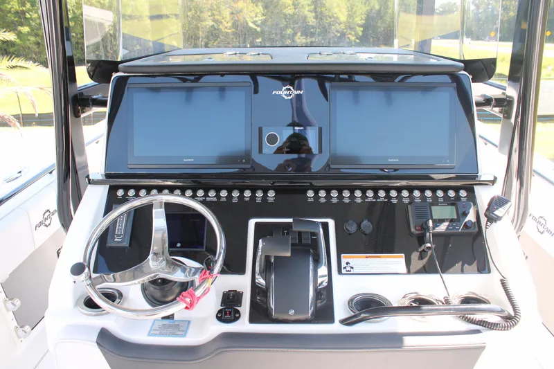 Slide: The Image of 2023 Fountain 34 CC boat dashboard with dual screens and steering wheel. - 20