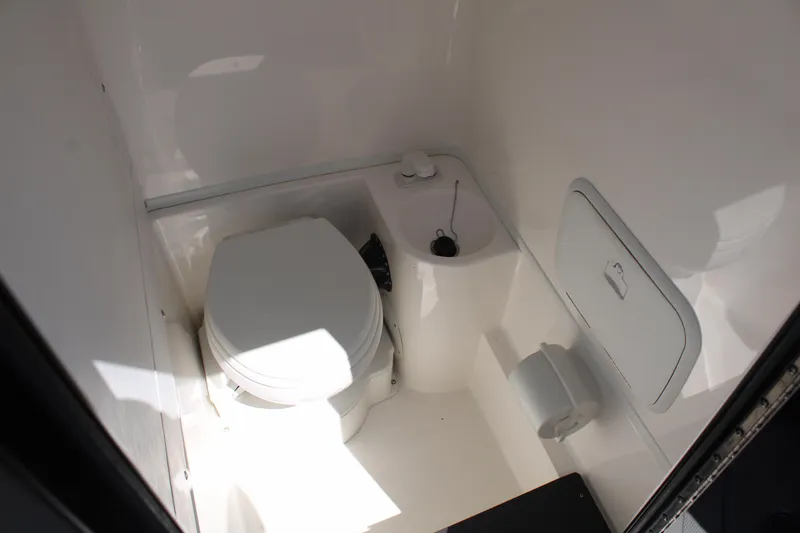 Slide: The Image of 2023 Fountain 34 CC boat interior bathroom with toilet and storage compartment. - 27