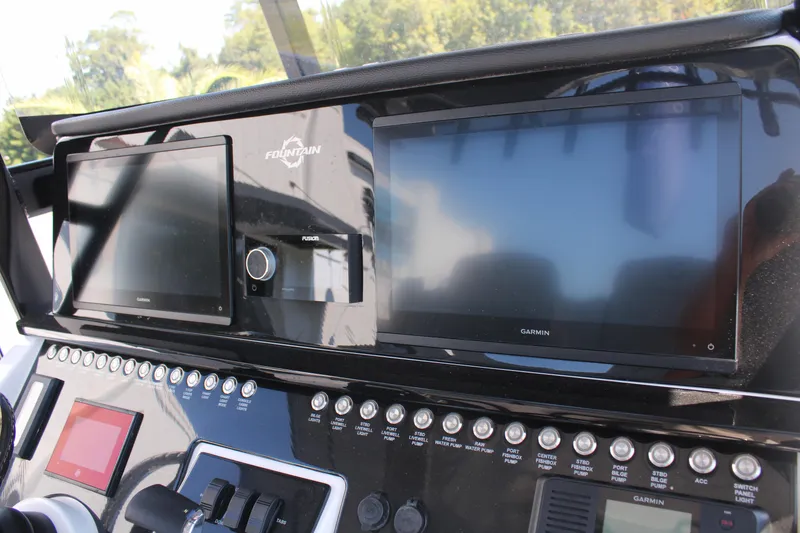 Slide: The Image of 2023 Fountain 34 CC boat dashboard with dual Garmin displays and control panel. - 33