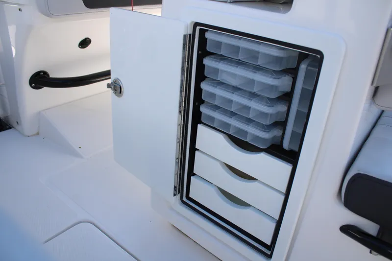 Slide: The Image of 2023 Fountain 34 CC boat storage compartment with organized tackle boxes and drawers. - 47