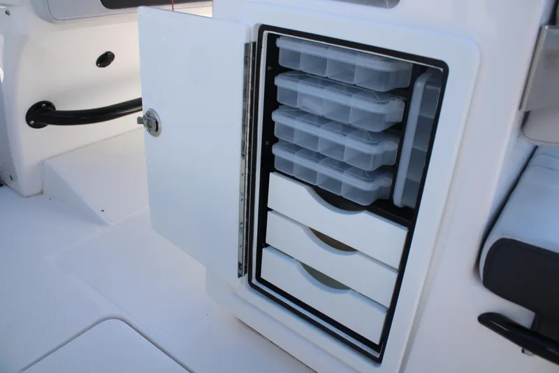 Slide: The Image of 2023 Fountain 34 CC boat storage compartment with organized tackle boxes and drawers. - 48