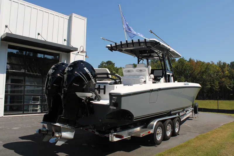 Slide: The Image of 2023 Fountain 34 CC boat on trailer with dual engines, parked outdoors. - 5