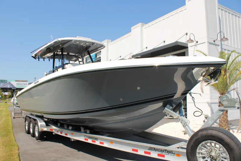 Slide: The Image of 2023 Fountain 34 CC boat on trailer, parked outdoors near a building. - 8