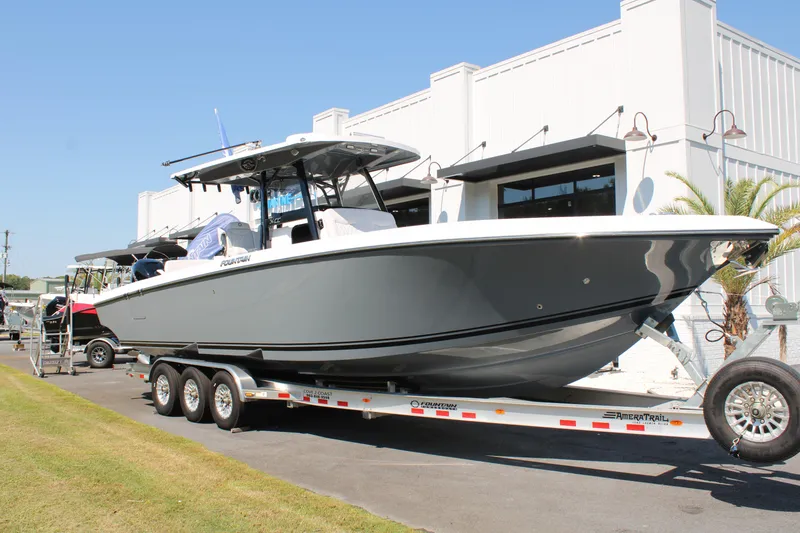 Slide: The Image of 2023 Fountain 34 CC boat on trailer, parked outside a building. - 9