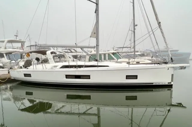 Slide: The Image of 2023 Beneteau Oceanis 46.1 yacht docked in a marina, reflecting on calm water. - 4