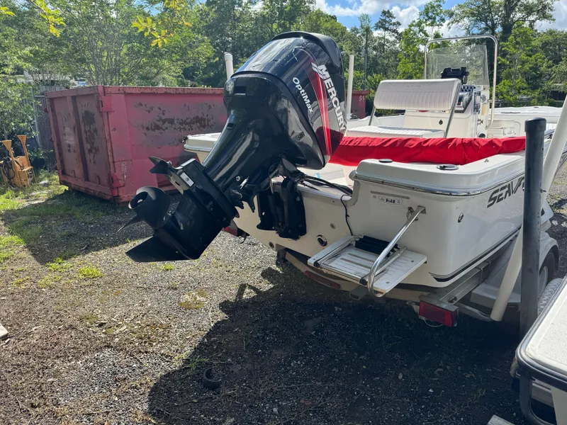 Slide: The Image of 2006 Sea Fox 185 Bay Fisher boat with outboard motor in a yard setting. - 4