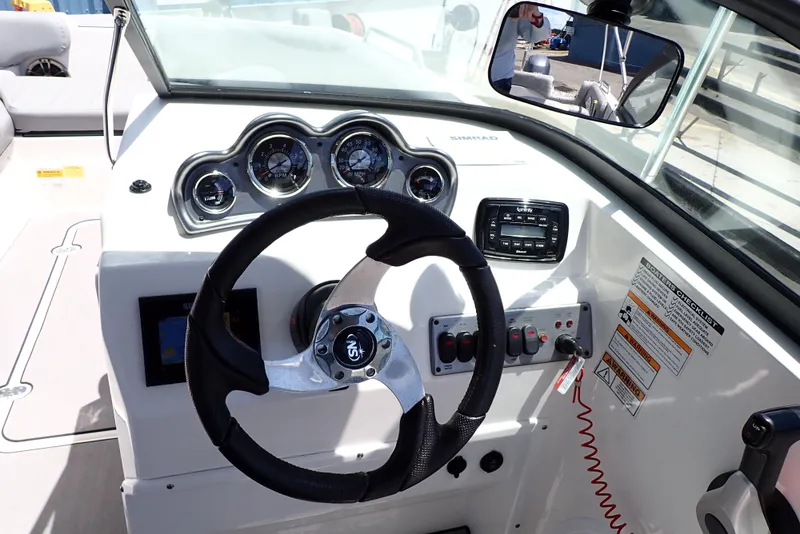 Slide: The Image of 2021 NauticStar 223 DC boat dashboard with steering wheel and control panel. - 10
