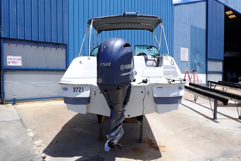 Slide: The Image of 2021 NauticStar 223 DC boat with Yamaha 150 engine, docked at a marina. - 2