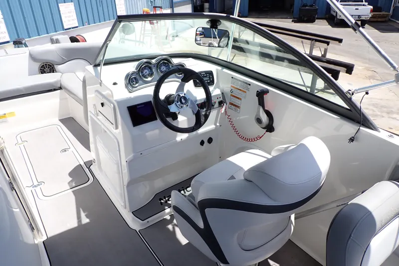 Slide: The Image of 2021 NauticStar 223 DC boat interior with steering wheel and dashboard controls. - 4