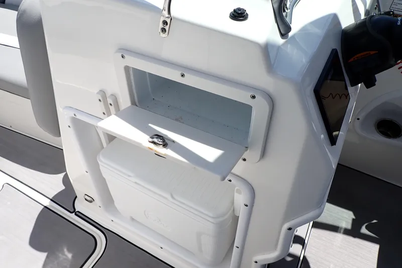 Slide: The Image of 2021 NauticStar 223 DC boat interior with storage compartment and cooler. - 43