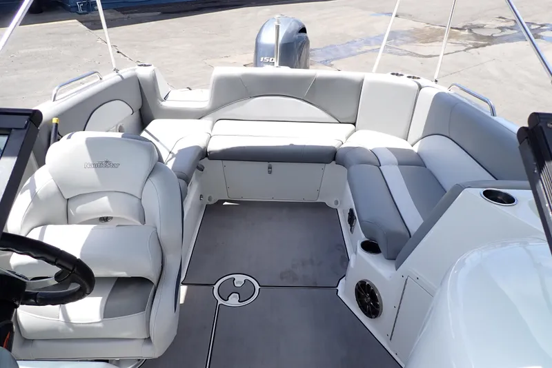 Slide: The Image of 2021 NauticStar 223 DC boat interior with gray seating and steering wheel. - 8