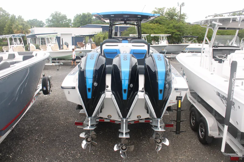 Slide: The Image of 2024 Fountain 34 SC boat with triple outboard engines, displayed in a marina. - 14