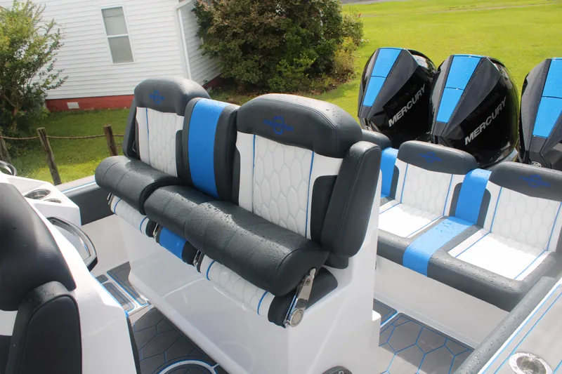 Slide: The Image of 2024 Fountain 34 SC boat seating with blue and white upholstery, featuring Mercury engines. - 25