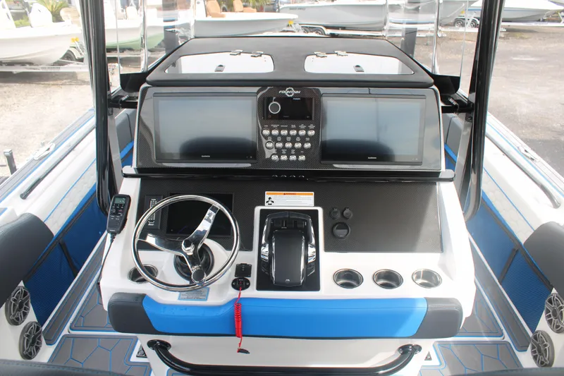 Slide: The Image of 2024 Fountain 34 SC boat dashboard with steering wheel and control panel. - 32