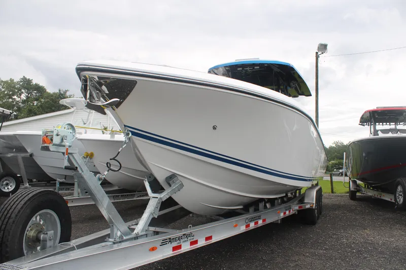 Slide: The Image of 2024 Fountain 34 SC boat on trailer, sleek white design with blue accents. - 7