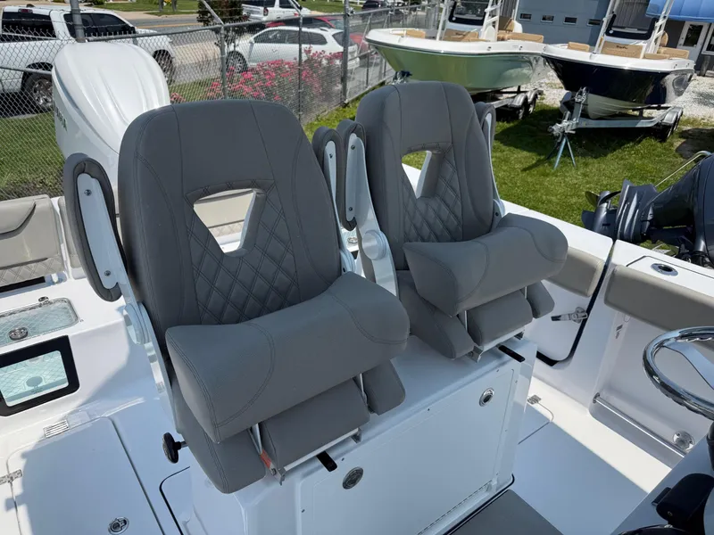 Slide: The Image of 2025 Sportsman Heritage 261 Center Console boat seats, gray upholstery, outdoor setting. - 14