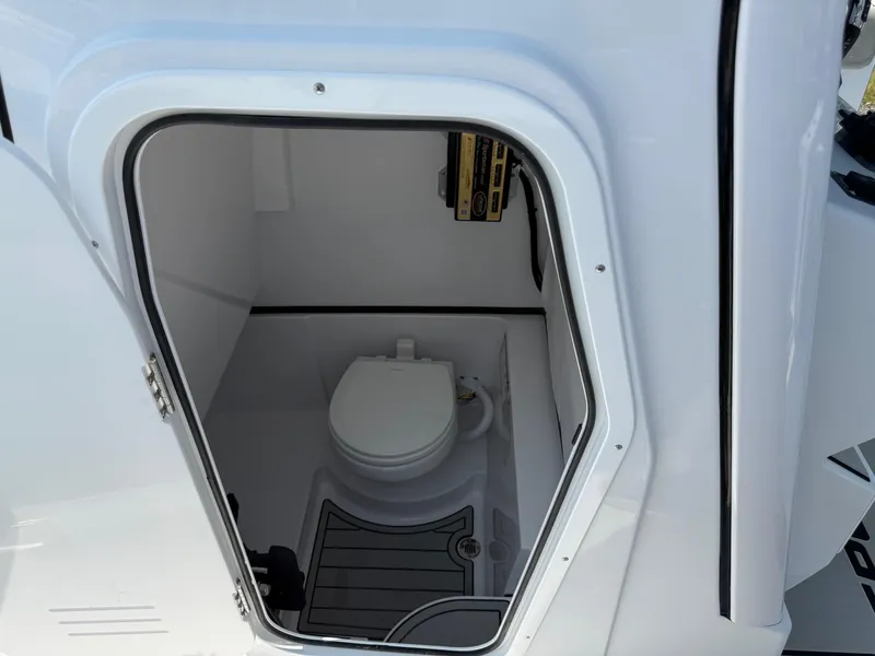Slide: The Image of 2025 Sportsman Heritage 261 Center Console boat interior with compact marine toilet. - 26