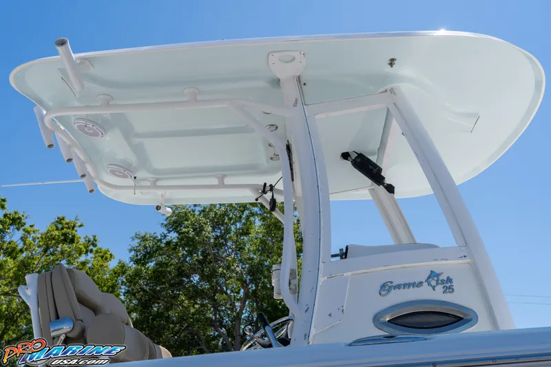 Slide: The Image of 2017 Sea Hunt Gamefish 25 boat with T-top, viewed from below against a clear blue sky. - 13