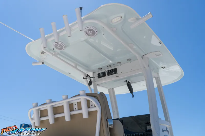 Slide: The Image of 2017 Sea Hunt Gamefish 25 boat T-top with rod holders and speakers against blue sky. - 14