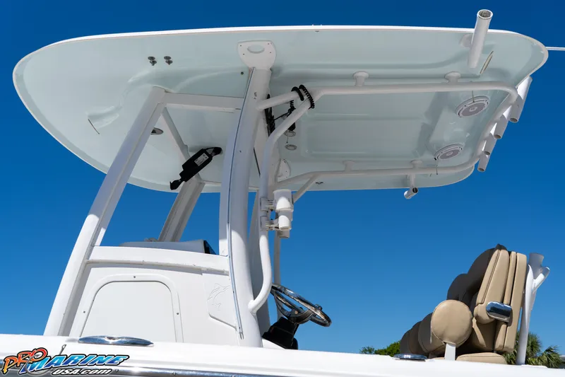 Slide: The Image of 2017 Sea Hunt Gamefish 25 boat with T-top and helm, under clear blue sky. - 15