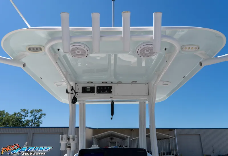 Slide: The Image of 2017 Sea Hunt Gamefish 25 boat T-top with rod holders and speakers, under clear blue sky. - 21