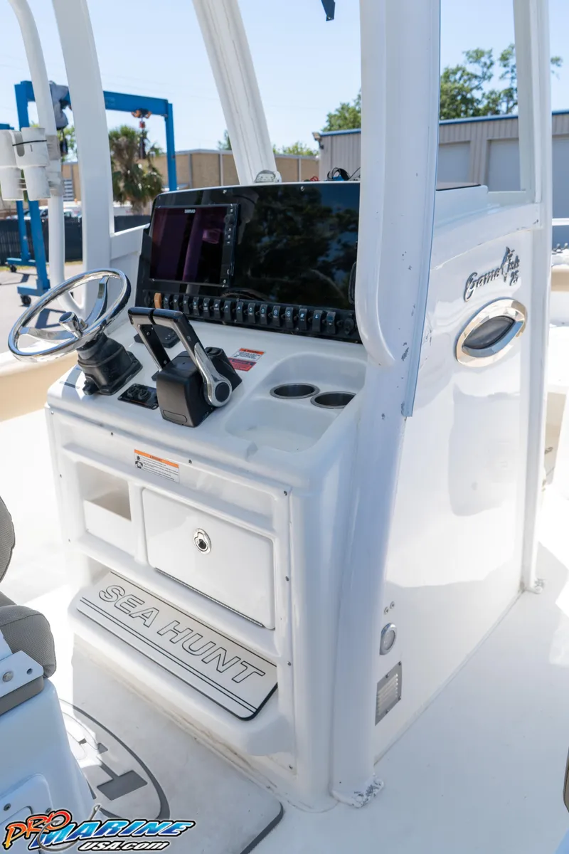 Slide: The Image of 2017 Sea Hunt Gamefish 25 boat console with steering wheel and navigation equipment. - 22
