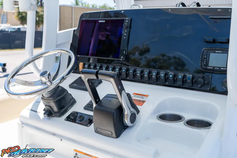 Slide: The Image of 2017 Sea Hunt Gamefish 25 boat dashboard with steering wheel and electronic controls. - 23