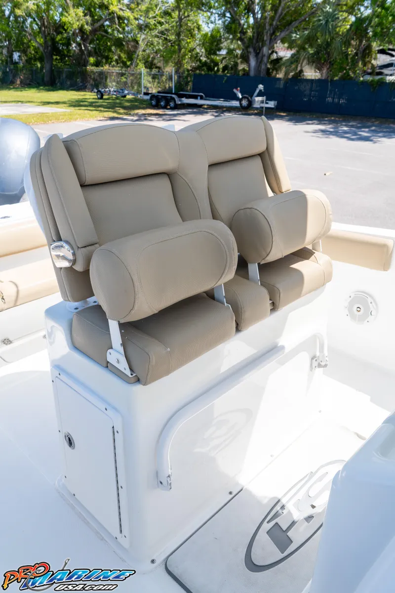 Slide: The Image of 2017 Sea Hunt Gamefish 25 boat seats with beige upholstery in a sunny outdoor setting. - 25
