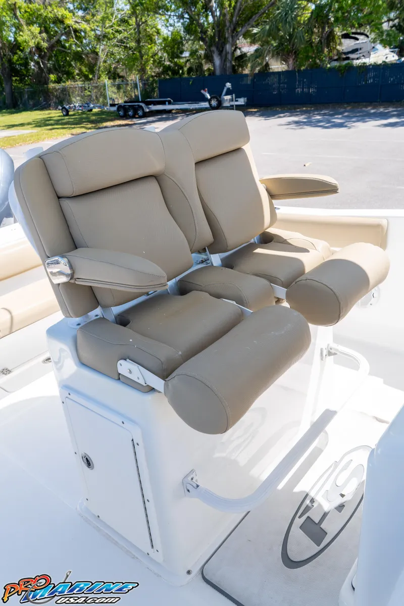 Slide: The Image of 2017 Sea Hunt Gamefish 25 boat seats with beige upholstery and armrests. - 26